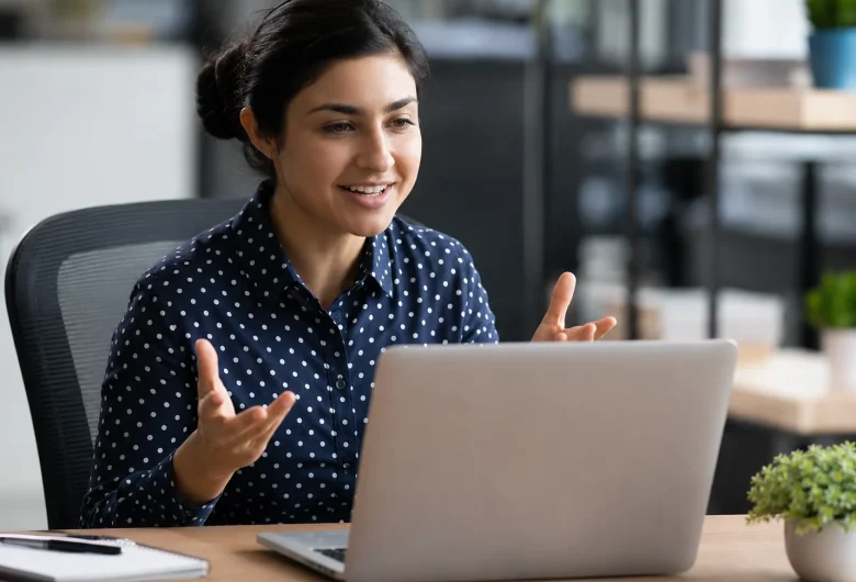 Smiling professional using expressive hand gestures to command attention during an online meeting. Manifesting elite communication skills and peak workplace confidence.